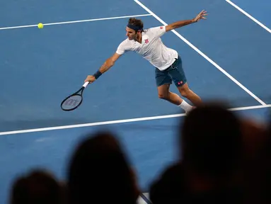 Petenis Swiss, Roger Federer berusaha mengembalikan bola ke arah Taylor Fritz dari AS dalam babak 32 besar Australia Terbuka di Melbourne, Jumat (18/1). Federer melaju mulus ke babak 16 besar setelah menang tiga set langsung 6-2 7-5 6-2. (AP/Kin Cheung)
