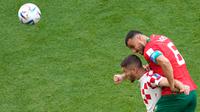 Pemain Kroasia Andrej Kramaric (kiri) dan pemain Maroko Romain Saiss melakukan sundulan pada pertandingan sepak bola Grup F Piala Dunia 2022 di Stadion Al Bayt, Al Khor, Qatar, Rabu (23/11/2022). Pertandingan berakhir imbang dengan skor 0-0. (AP Photo/Darko Vojinovic)