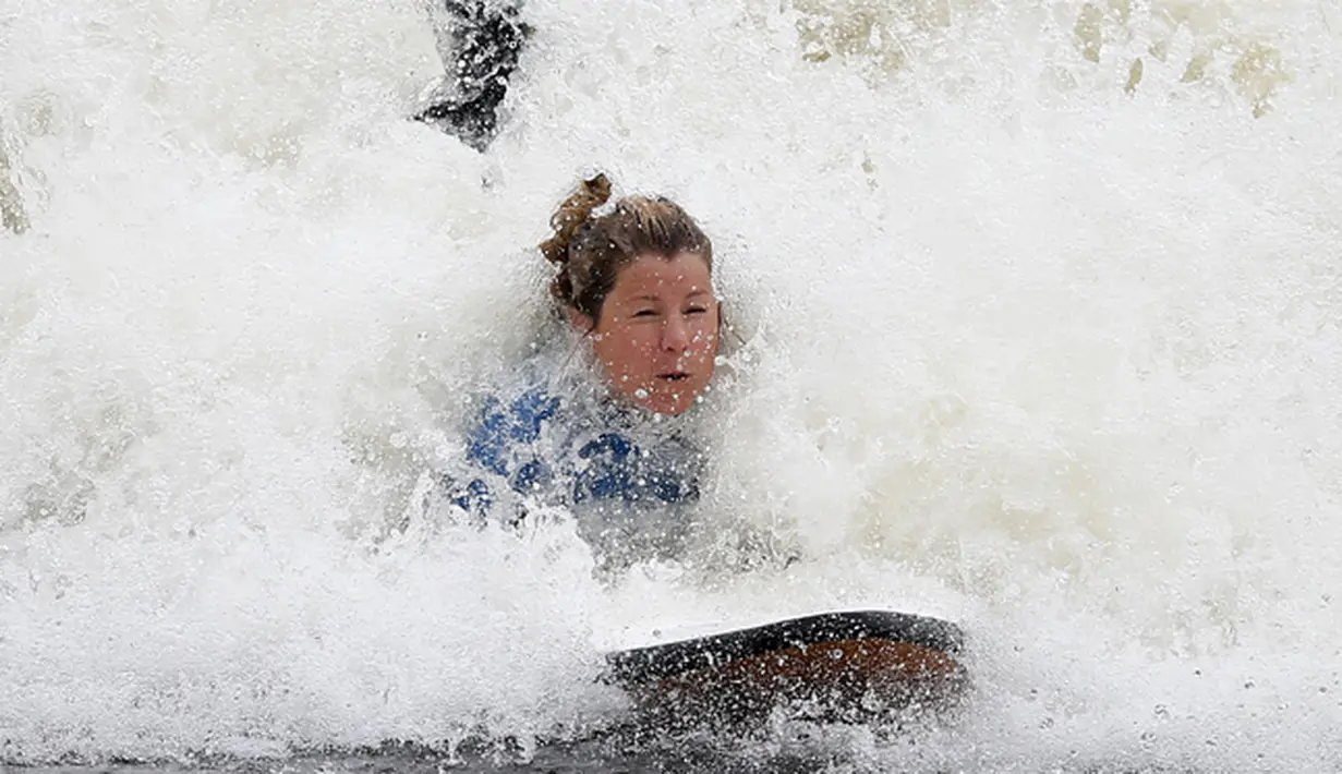 Seorang wanita saat menikmati berselancar di Surf Snowdonia, Conwy, North Wales, Kamis (3/9/2015).  Ukuran tinggi gelombang di Danau buatan ini bisa mencapai 300 meter dan panjang 110 meter dan berisi sekitar enam juta galon air . (REUTERS/Andrew Yates) 