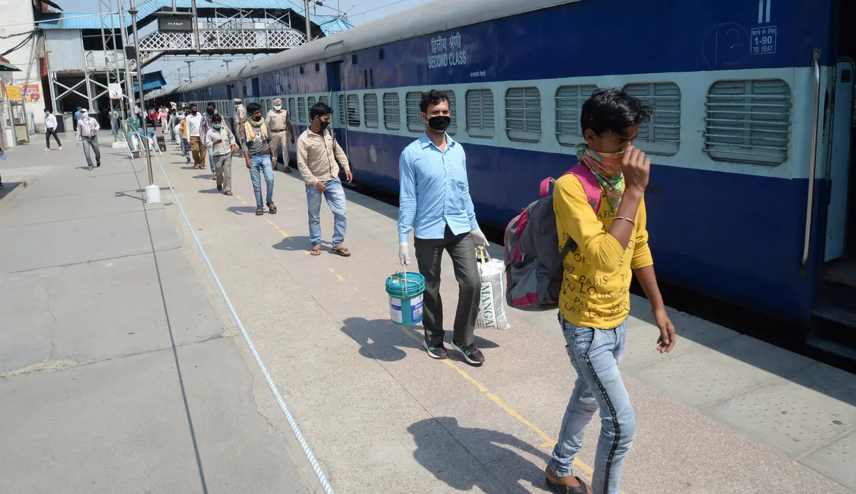Para buruh migran berjalan untuk menaiki kereta khusus menuju rumah mereka saat masa karantina wilayah (lockdown) nasional yang diterapkan demi mencegah penyebaran COVID-19 di Jalandhar, Negara Bagian Punjab, India utara, (5//5/2020). (Xinhua/Stringer)