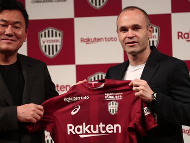 Mantan pemain Barcelona, Andres Iniesta (kanan) memegangn jersey bersama Presiden klub Vissel Kobe, Hiroshi Mikitani di Tokyo, (24/5/2018). Andres memilih bergabung dengan Vissel Kobe selama tiga musim. (AFP/Behrouz Mehri)