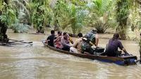 Evakuasi dan distribusi logistik Pilkada dari TPS yang terendam banjir ke lokasi aman. (Liputan6.com/M Syukur)