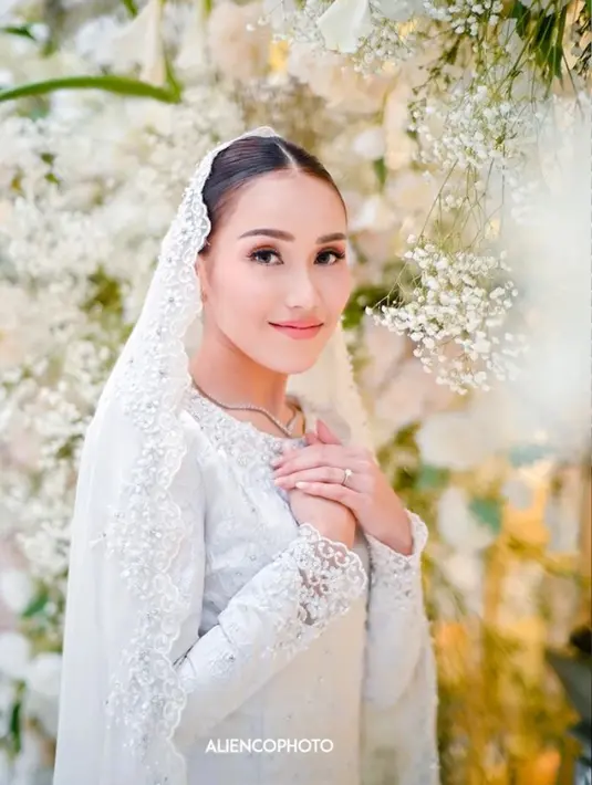 Baju kurung putih dengan kerudung berhias bordir pinggir merupakan gaya yang sangat anggun dan abadi untuk hari raya. Putih memberikan kesan suci dan elegan, sementara hiasan bordir pinggir pada kerudung memberikan detail yang unik.  [Foto: Instagram/ayutingting92]