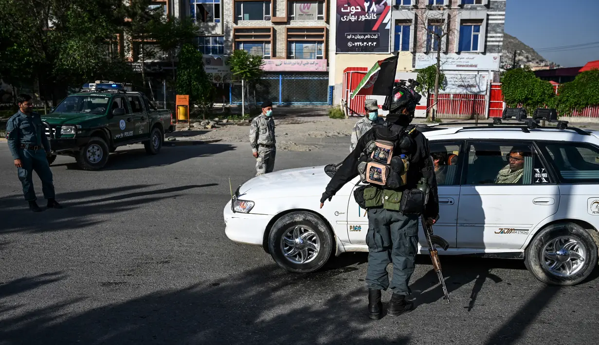 Petugas keamanan menghentikan pengendara mobil saat Hari Raya Idul Fitri di pos pemeriksaan di Kabul, Afghanistan, Minggu (24/5/2020). Taliban mengumumkan gencatan senjata selama tiga hari dengan pemerintah Afghanistan setelah berbulan-bulan bertempur. (WAKIL KOHSAR/AFP)