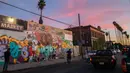 Orang-orang berkumpul di depan mural karya Muck Rock dan Mr79lts yang memperlihatkan Kobe Bryant dan putrinya, Gianna Bryant di Los Angeles, Senin (27/1/2020). Pemain basket legendaris NBA Kobe Bryant bersama putrinya, Gianna tewas dalam kecelakaan helikopter pada Senin (27/1). (Apu GOMES/AFP)
