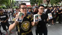 Pelanggan pertama menunjukkan iPhone X setelah ia membelinya di Singapura (3/11). (AFP Photo/Roslan Rahman)