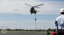 Anggota Paskhas (Pasukan Khas) TNI AU menuruni helikopter menggunakan tali saat unjuk kebolehan simulasi penyelamatan sandera dalam rangkaian acara HUT TNI AU di Halim Perdanakusuma, Minggu (9/4). TNI AU memperingati HUT ke-71 (Liputan6.com/Faizal Fanani)