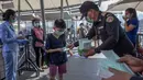 Petugas memberikan masker pelindung untuk pengunjung di sebuah mal mewah di Bangkok, Thailand  (28/1/2020). Ketakutan terhadap virus corona dari China membuat persediaan masker semakin menipis di beberapa pusat penjualan. (AP Photo/Gemunu Amarasinghe)