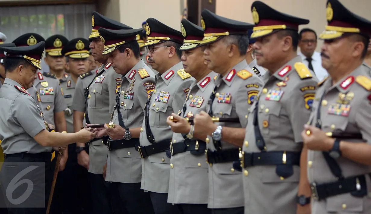 Kapolri Jenderal Tito Karnavian (kiri) saat memberikan tongkat komando kepada Kapolda Papua yang baru Irjen Boy Rafli Amar saat acara pelantikan perwira tinggi kepolisian di Mabes Polri, Jakarta, Jum'at (28/4). (Liputan6.com/Johan Tallo)