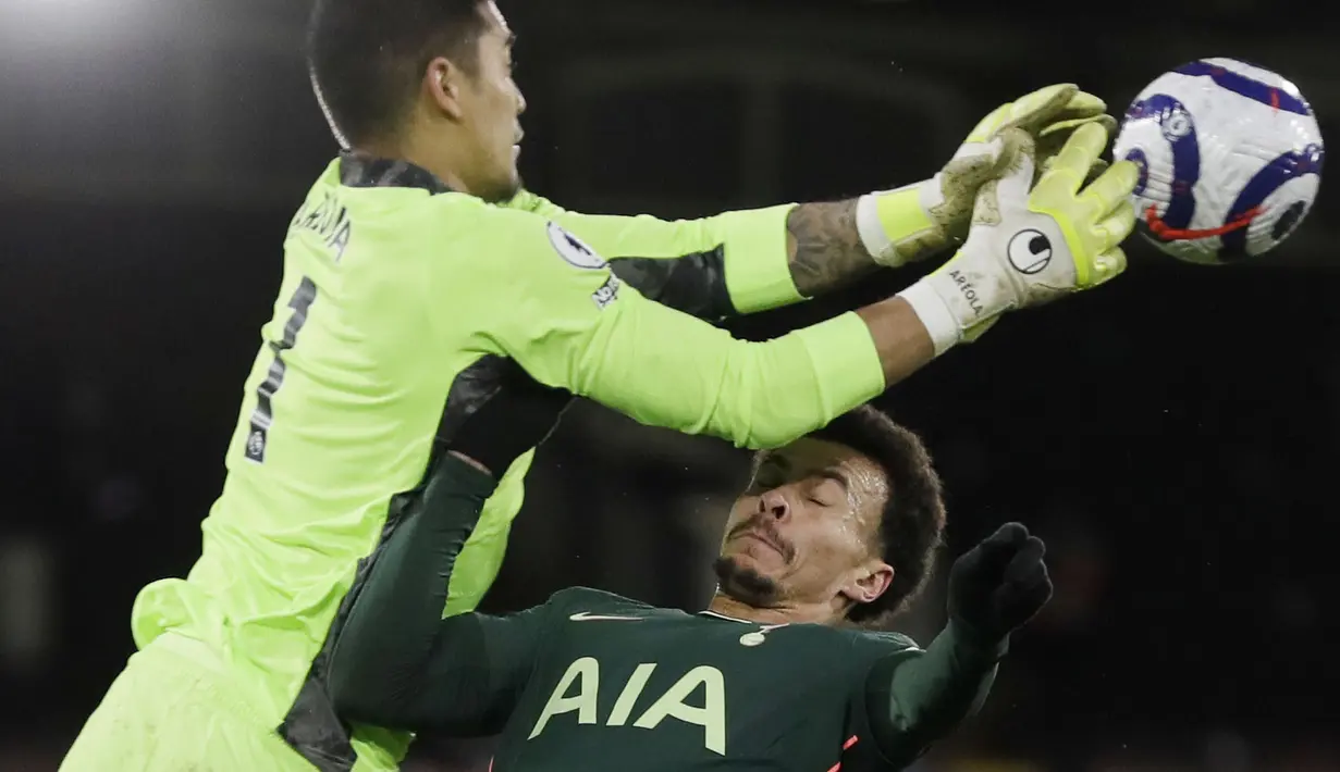 Penyerang Tottenham Hotspur, Dele Alli, duel udara dengan kiper Fulham, Alphonse Areola, pada laga Liga Inggris di Stadion Craven Cottage, Kamis (4/3/2021). Tottenham Hotspur menang dengan skor 1-0. (Neil Hall/Pool via AP)
