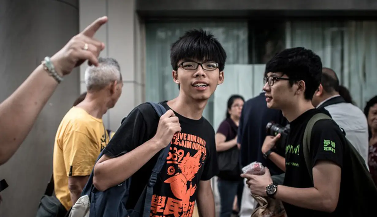 Pemimpin Mahasiswa pengunjuk rasa, Joshua Wong (tengah) tiba di pengadilan Hong Kong, Cina, Jumat (28/8/2015). Wong dituntut atas tuduhan memanjat pagar kompleks gedung pemerintah pada awal demonstrasi. (AFP PHOTO/Philippe Lopez)
