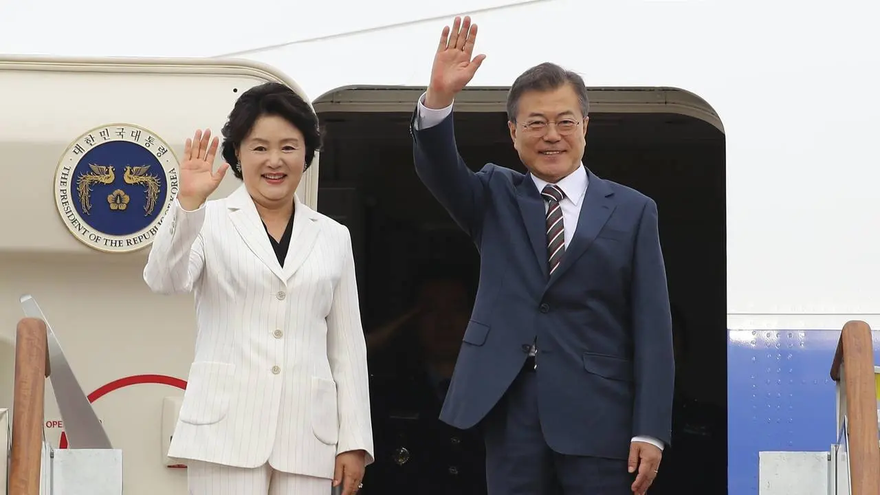 Ibu negara Korea Selatan Kim Jung-sook bersama Presiden Moon Jae-in melambaikan tangan dari atas pesawat kepresidenan (AP/Hwang Kwang Mo)