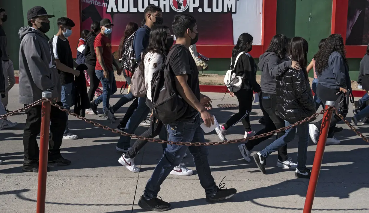 Anak-anak usai divaksin COVID-19 dalam program vaksinasi untuk anak-anak berusia 15 hingga 17 tahun di Stadion Caliente, Tijuana, Baja California, Meksiko, 24 November 2021. Meksiko bersiap menghadapi gelombang keempat infeksi virus corona COVID-19. (Guillermo Arias/AFP)