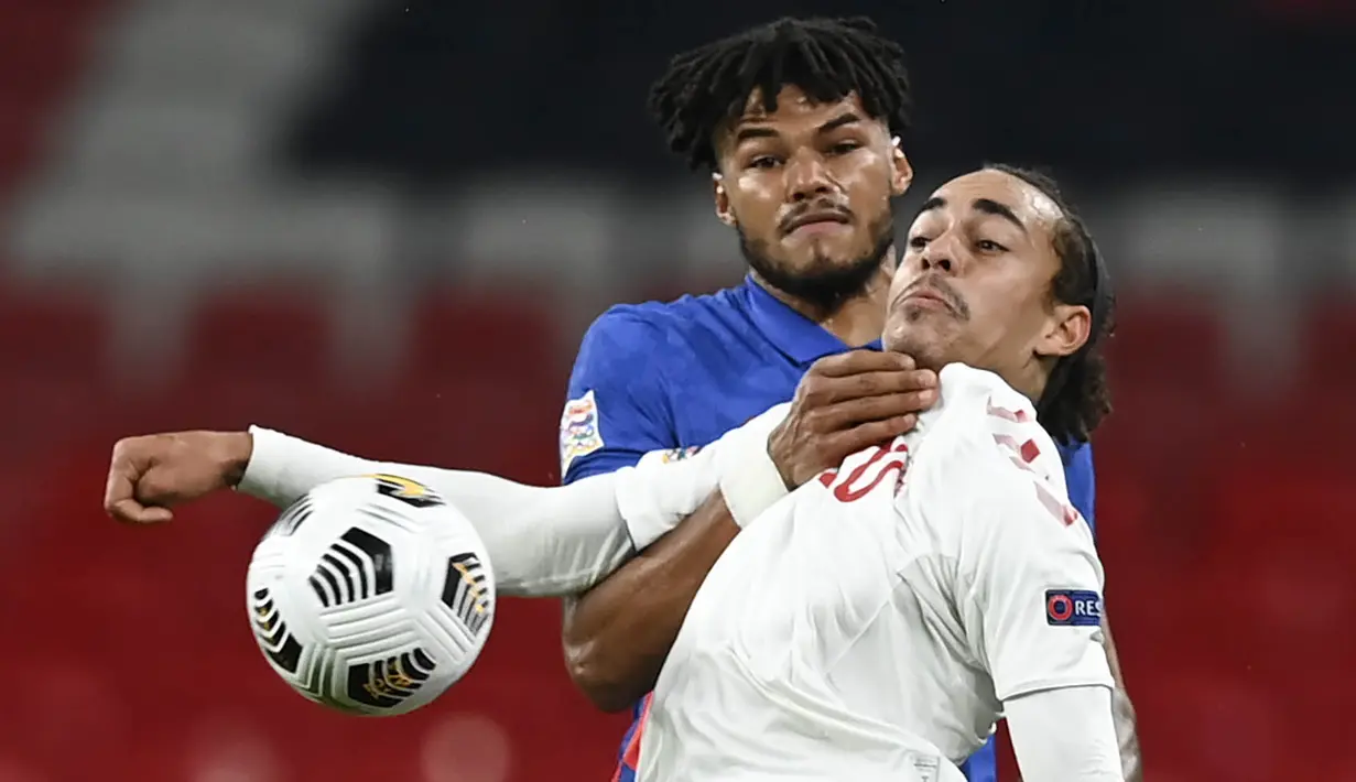 Pemain Inggris, Tyrone Mings, berebut bola dengan pemain Denmark, Yussuf Poulsen, pada laga UEFA Nations League di Stadion Wembley, Kamis (15/10/2020). Denmark menang dengan skor 1-0. (Daniel Leal-Olivas/Pool via AP)
