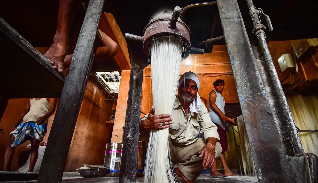 Pekerja menyiapkan bihun yang digunakan untuk membuat hidangan manis tradisional yang populer dikonsumsi selama bulan suci Ramadhan, di sebuah pabrik di Allahabad, India (5/4/2022). (AFP/Sanjay Kanojia)