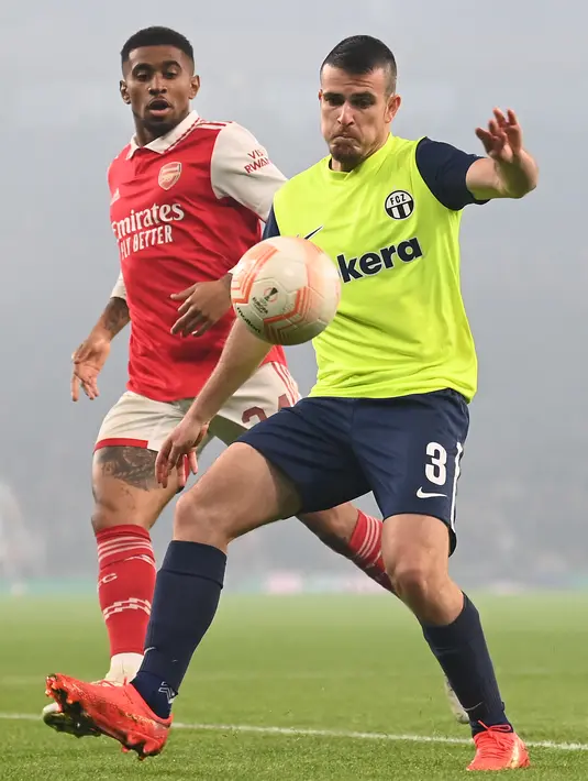 Gelandang Arsenal Reiss Nelson (kiri) bersaing dengan bek FC Zurich Adria Guerrero pada matchday terakhir Grup A  Liga Europa 2022/2023 di Emirates Stadium, Jumat (4/11/2022) dinihari WIB. Poin penuh Arsenal kontra juara Liga Swiss itu datang berkat tembakan bek kiri Kieran Tierney pada menit ke-17. (Photo by Glyn KIRK / AFP)