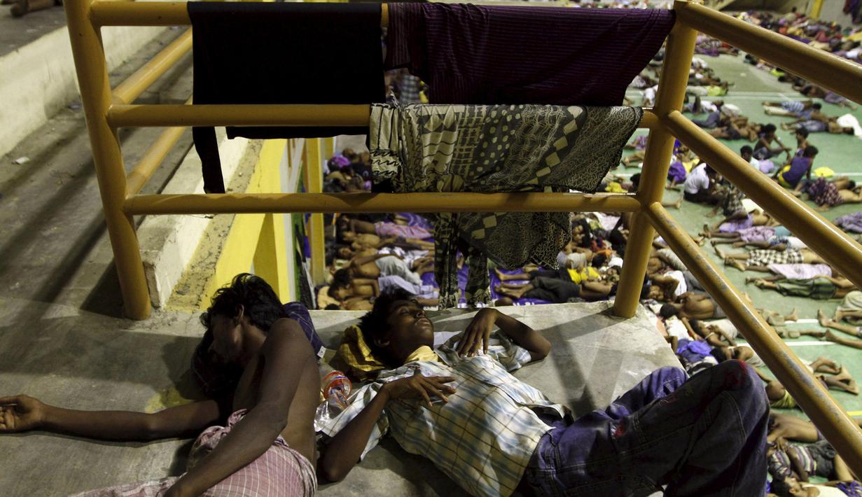 Dua pemuda etnis Rohingya tidur di tempat penampungan di Lhoksukon, Aceh, Senin (11/5/2015). Sekitar 500 migran terdampar di pantai Aceh setelah terapung-apung di laut selama sebulan karena kehabisan bahan bakar. (REUTERS/Roni Bintang)