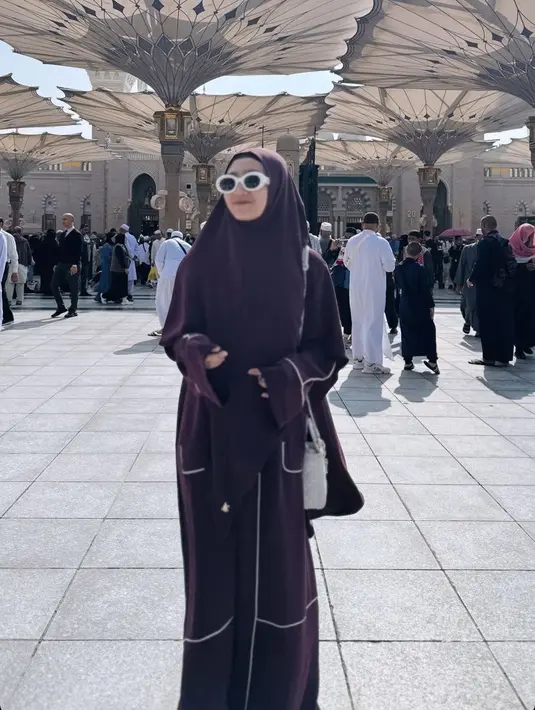 Ia juga mengenakan abaya warna coklat dengan aksen putih, serasi dengan kerudungnya. Melengkapi penampilannya dengan kacamata hitam berbingkai putih dan tas Diornya.[@febbyrastanty]