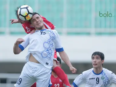Duel pemain  Uzbekistan, Gofurov Husniddin (tengah) dengan pemain Korea Utara pada PSSI Anniversary Cu 2018 di Stadion Pakansari, Bogor, (26/4/2018). Uzbekistan bermain imbang  2-2. (Bola.com/Nick Hanoatubun)