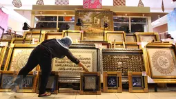 Pedagang tengah menata kaligrafi di pusat perbelanjaan di Jakarta, Rabu (22/6). Kaligrafi dijual dengan kisaran harga jual ratusan hingga puluhan juta rupiah tergantung motif dan tingkat kesulitan pembuatan. (Liputan6.com/Angga Yuniar)