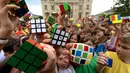 Murid-murid Hungaria berpose dengan Kubus Rubik usai melakukan flashmob di Budapest pada 12 Juni 2024. (Ferenc ISZA/AFP)