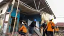 Tim penyelamat membantu warga mencari barang-barang berharga dari reruntuhan rumah mereka yang rusak akibat gempa bumi berkekuatan magnitudo 6,3 di Kelurahan Betungan, Provinsi Bengkulu pada Jumat 23 Mei 2025. (DIVA MARHA/AFP)