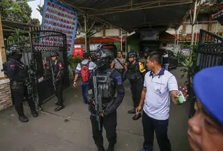 Petugas tim penjinak bom berjaga di pintu masuk SMAN 72 Jakarta pada 7 November 2025. Sebuah ledakan terjadi di SMAN 72 Jakarta di kawasan Kecamatan Kelapa Gading, Jakarta Utara, pada Jumat 7 November 2025 siang. (CANDRA/AFP)