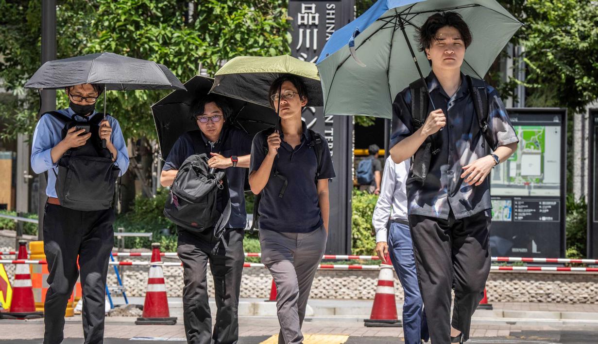 Orang-orang melindungi diri dari terik matahari dengan payung di Tokyo pada 27 Agustus 2025. (Yuichi YAMAZAKI/AFP)