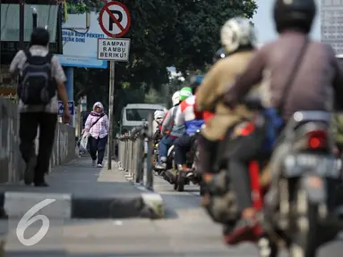 Seorang pejalan kaki melintas melalui trotoar dikawasan Sudirman, Jakarta, Senin (18/4). Gubernur Basuki T Purnama berencana memperlebar trotoar sampai 9,5 meter agar mempermudah orang berjalan kaki usai naik kereta atau bus. (Liputan6.com/Faizal Fanani)