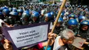 Polisi anti huru hara berjaga-jaga di depan Kedutaan Besar AS saat aksi protes berlangsung AS di Manila, Jumat (28/4). Demonstran mengecam imperealisme yang dilakukan oleh Amerika Serikat, Jepang dan China atas Asia Tenggara. (AP Photo / Bullit Marquez)