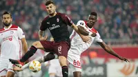 Pemain AC Milan Patrick Cutrone dan pemain Olympiakos Piraeus, Pape Abou Cisse berebut bola dalam laga keenam Grup F Liga Europa di Stadion Georgios Karaiskakis, Kamis (13/12). Milan tersingkir dari Liga Europa setelah kalah 1-3. (AP/Petros Giannakouris)