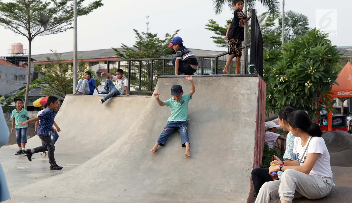 Seorang anak bermain meluncur di area Skate Park RPTRA Kalijodo, Jakarta, Sabtu (15/6/2019). Menjelang sore hari, anak-anak berdatangan menghabiskan waktu dengan bermain di area RPTRA Kalijodo. (Liputan6.com/Helmi Fithriansyah)