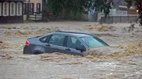 Sebuah mobil terjebak dalam banjir yang menggenangi Ellicott City, Maryland (27/5). Banjir bandang melanda kota Maryland pada Minggu (27/5) waktu setempat. (Kenneth K. Lam / The Baltimore Sun via AP)