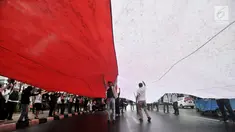 Massa GJI membentangkan bendera Merah Putih raksasa saat menggelar aksi menuntut Gubernur DKI Jakarta Anies Baswedan untuk mencabut izin penyelanggaraan Reuni 212 di depan Balai Kota, Jakarta, Kamis (29/11). (Merdeka.com/Iqbal S. Nugroho)
