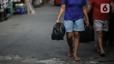 Warga membawa barang belanjaan dengan menggunakan kantong plastik di Kawasan Pasar Jatinegara, Jakarta, Selasa (30/6/2020). Pemerintah Provinsi DKI Jakarta bakal resmi menerapkan larangan penggunaan kantong plastik sekali pakai mulai Rabu, 1 Juli 2020 besok. (Liputan6.com/Faizal Fanani)