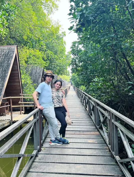 Tak hanya melihat pemandangan lewat perahu, Tissa Biani dan Dul Jaelani terlihat asyik berjalan di jembatan kayu. Lebih dalam menyusuri hutan mangrove sambil melepas penat dalam obrolan bareng. (Liputan6.com/IG/@tissabiani).