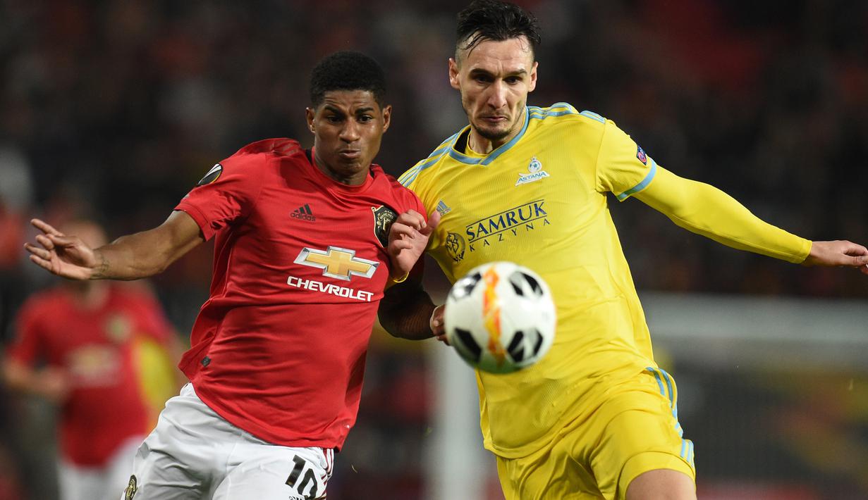 Striker Manchester United, Marcus Rashford, berebut bola dengan bek Astana, Zarko Tomasevic, pada laga Europa League di Stadion Old Trafford, Manchester, Kamis (19/9). MU menang 1-0 atas Astana. (AFP/Oli Scarff)