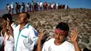 Ekpresi sejumlah pengunjung saat mengikuti perayaan equinox musim semi di situs arkeologi Teotihuacan, Meksiko (21/3). Equinox ini terjadi dua kali dalam setahun, yakni pada Maret dan September. (AP Photo/Rebecca Blackwell)