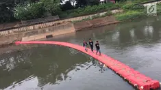 Anak-anak melintasi penyaring sampah untuk menyeberangi Kanal Banjir Timur di Jakarta, Kamis (28/12). Keberadaan penyaring sampah tersebut dimanfaatkan warga sebagai sarana menyeberang untuk mempersingkat waktu tempuh. (Liputan6.com/Immanuel Antonius)