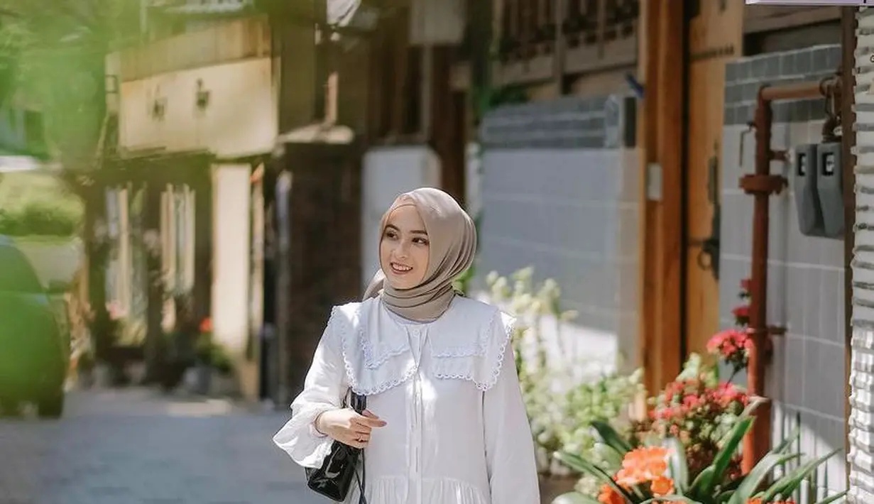 Kombinasi tunik dengan detail kerah Korea warna putih yang dipadukan dengan rok plisket warna senada bersama hijab warna  cokelat pastel tak kalah menarik untuk ditiru, Simpel tapi feminin! (Instagram/biancakartika).