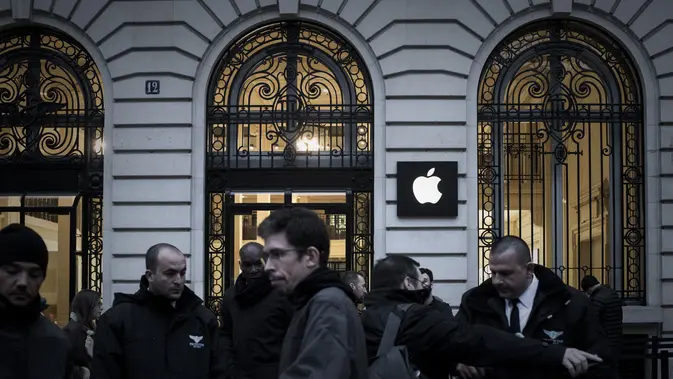 Karyawan Apple berdiri di luar toko Apple pada hari peluncuran iPhone X di Paris pada 3 November 2017. Philippe Lopez/AFP