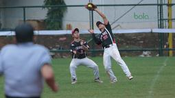 Dua pemain Singapura berebut bola saat melawan Indonesia pada laga Asian Softball Championship di Senayan, Jakarta,Selasa (25/4/2018). Indonesia menang atas Singapura 8-2. (Bola.com/Nick Hanoatubun)