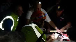 Petugas saat mengecek kondisi bayi gempa melanda pulau wisata di Ischia, di lepas pantai Napoli, Italia (21/8). Gempa berkekuatan 4.0 skala Richter (SR) membuat beberapa bangunan hancur. (AFP Photo/Mauro Pagnano)