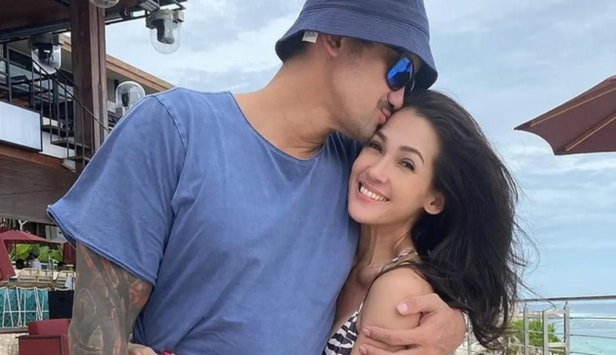 Tak lupa pose mesra dengan suami yang wajib dilakukan. Keduanya tampak mesra dan bahagia menghirup udara segar pantai. [Instagram @mieke_amalia]