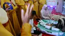Seorang bayi menjalani ritual 'peutron tanoh aneuk' (turun tanah anak) di Banda Aceh, Aceh, Senin (15/7/2019). Ritual turun tanah anak telah menjadi tradisi sakral bagi masyarakat Aceh yang dilaksanakan pada saat bayi berusia 44 hari. (CHAIDEER MAHYUDDIN / AFP)