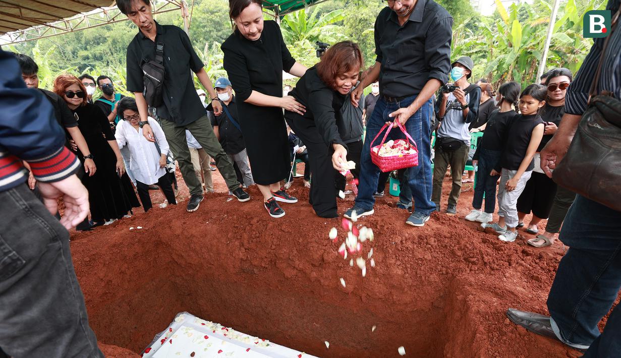 Pihak keluarga yang diwakili sang istri, Hendrita Pasaribu melakukan tabur bunga dalam prosesi pemakaman mantan pelatih Timnas Indonesia, Benny Dolo di Tempat Pemakaman Umum (TPU) Pondok Benda, Pamulang, Tangerang Selatan, Sabtu (4/2/2023) siang WIB. Bendol, sapaan akrabnya, meninggal dunia pada Rabu (1/2/2023) karena sakit. (Bola.com/M Iqbal Ichsan)