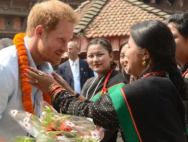 Panchakanya atau lima perawan khas budaya tradisional Nepal menyambut kedatangan Putra Mahkota Kerajaan Inggris, Pangeran Harry,  saat mengunjungi salah satu situs warisan Patan Durbar Square di Kathmandu, Minggu (20/3). (REUTERS/Prakash Mathema/Pool)