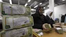 Pegawai menumpuk paket mata uang di Bank Sentral Suriah, Damaskus, Suriah, 13 Januari 2010. Gejolak krisis ekonomi Suriah lebih menyulitkan bagi masyarakat yang sehari-hari mesti berhadapan dengan perang sipil sejak tahun 2011. (AP Photo/Hussein Malla, File)