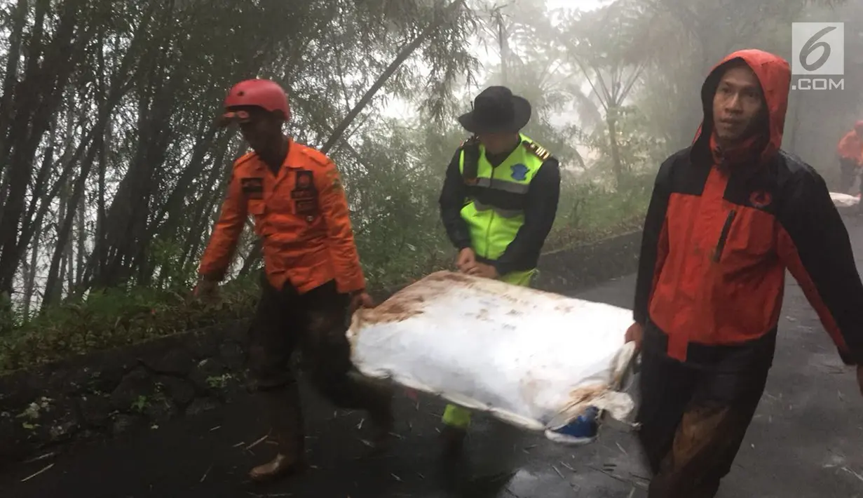 Petugas mengevakuasi lokasi longsor yang terjadi di kawasan Puncak Bogor, Jawa Barat (6/2). Dalam bencana longsor ini dua korban tewas, tiga orang terluka. Sementara empat lainnya belum diketahui keberadaannya. (Liputan6.com/Pool/Polres Bogor)