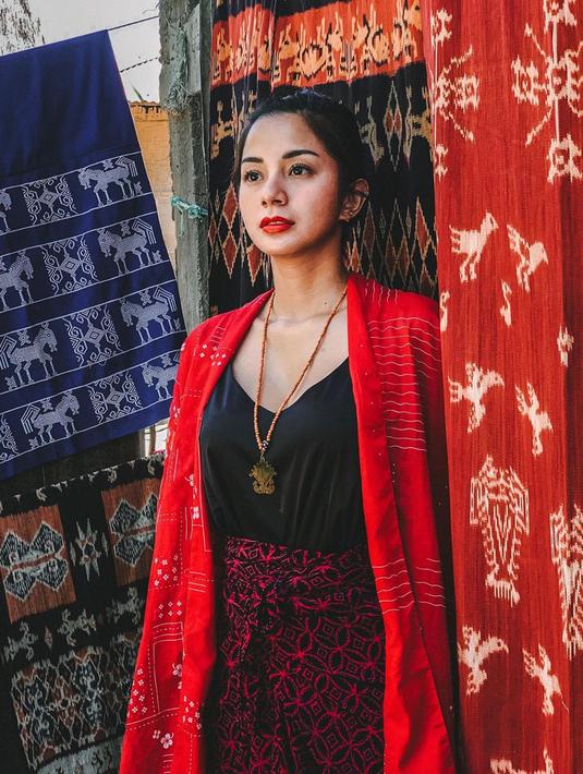 Pesonanya semakin terpancar kala memakai kebaya ombak laut semanggi merah. Berfoto dengan latar belakang kain tenun ikat Sumba, ibu satu anak ini tampak awet muda di usianya ke 32 tahun. (Liputan6.com/IG/@kiranalarasati)